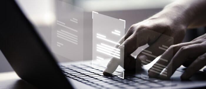 Hand using laptop computer with virtual screen and document for online approve paperless quality assurance and ERP management concept.
